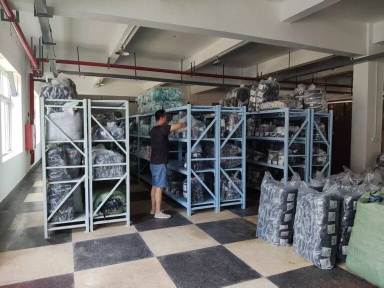 Finished dog harness inventory stored on metal racks, staff checking packed products in the warehouse.